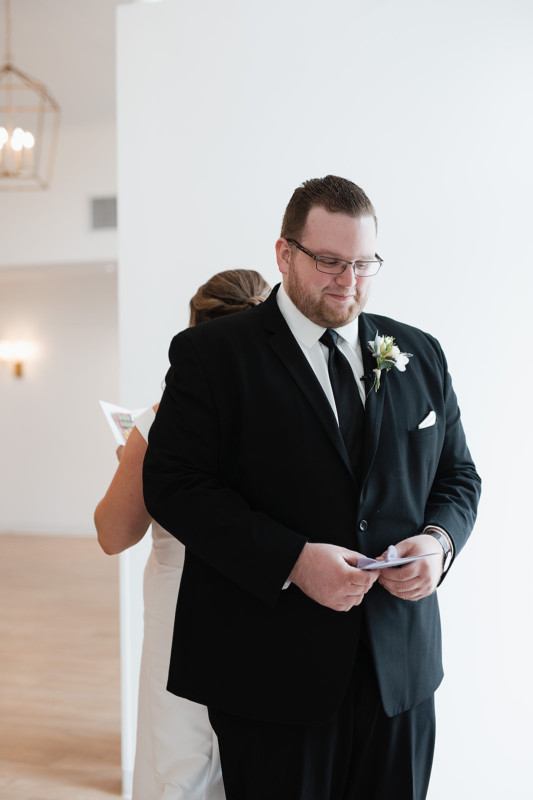 A couple standing back-to-back reading their private vows