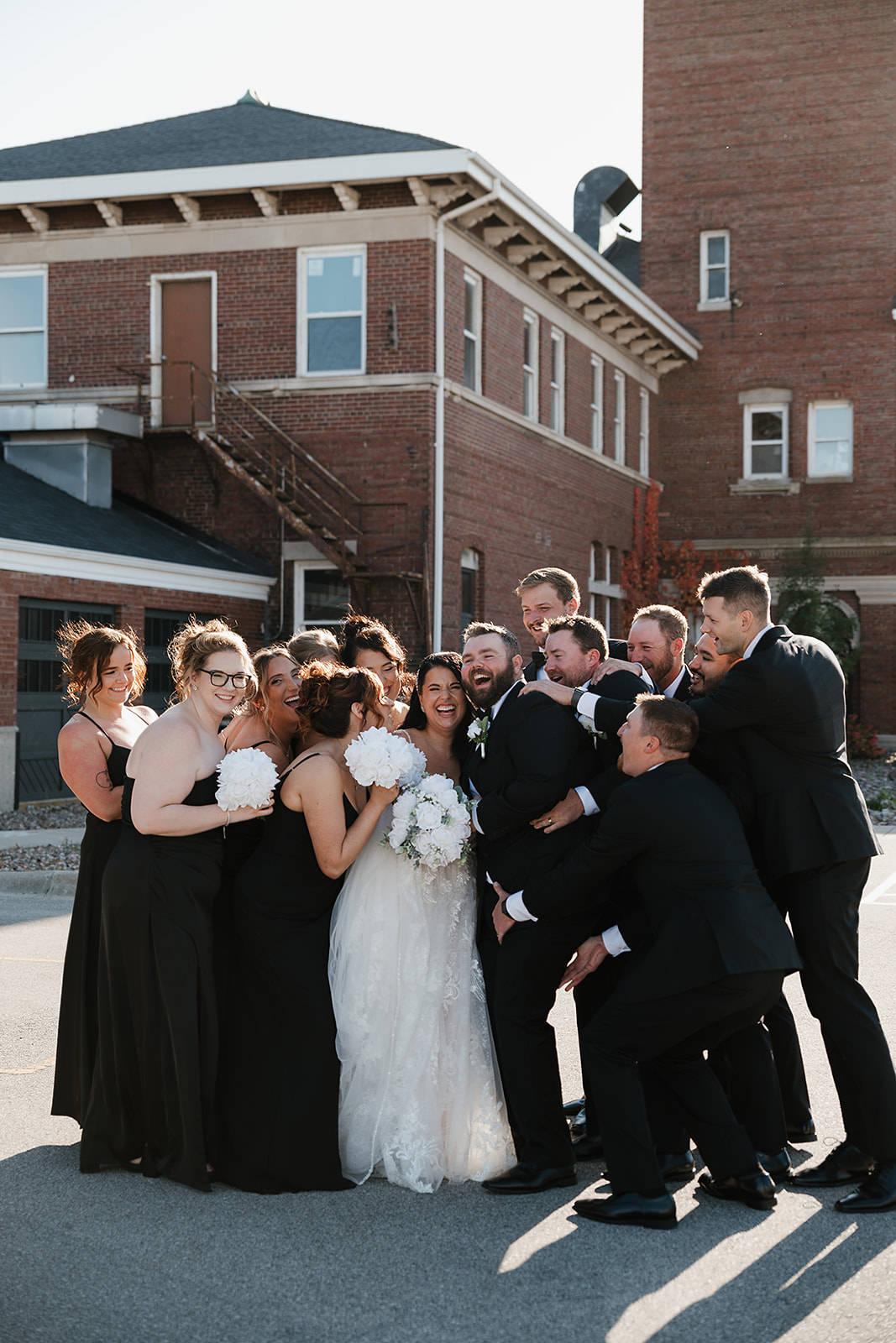 Large group cheering and celebrating with bride and groom