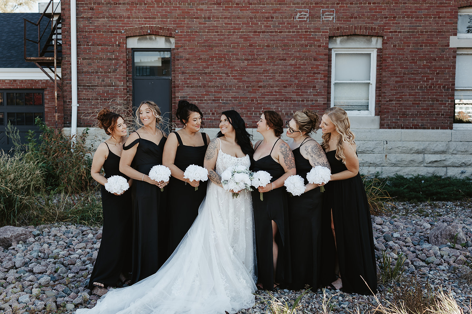 Bride with bridesmaids in black dresses holding bouquets
