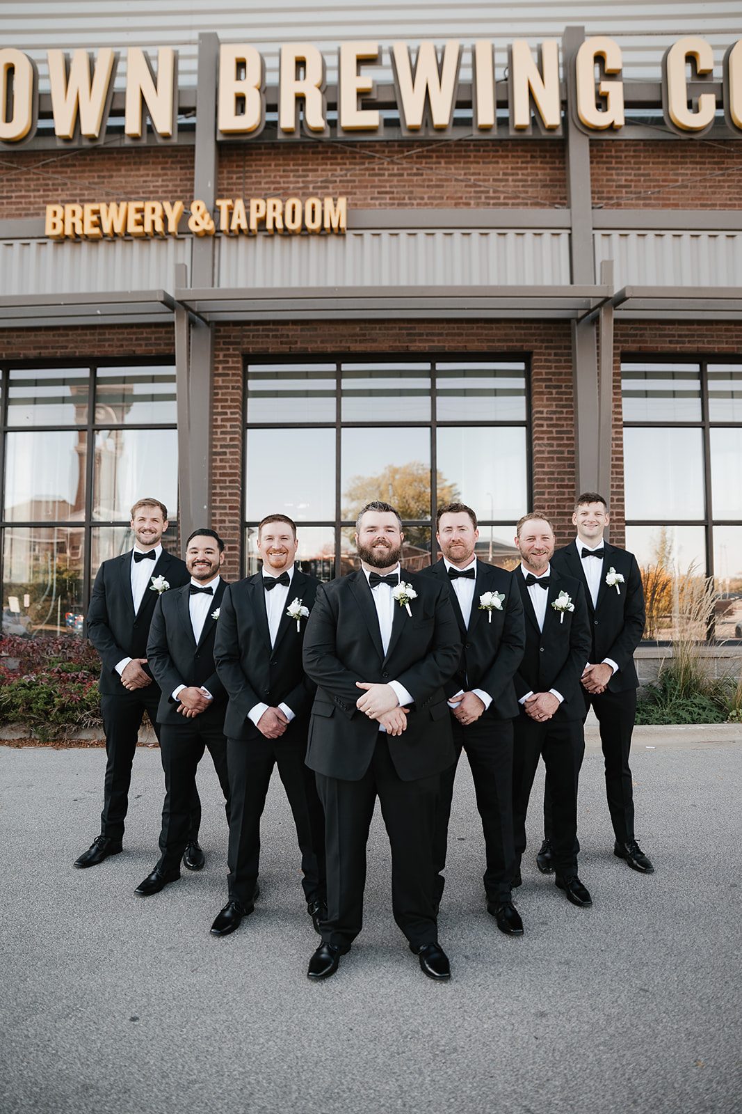 Wedding party posing outside industrial brick Green Bay wedding venue