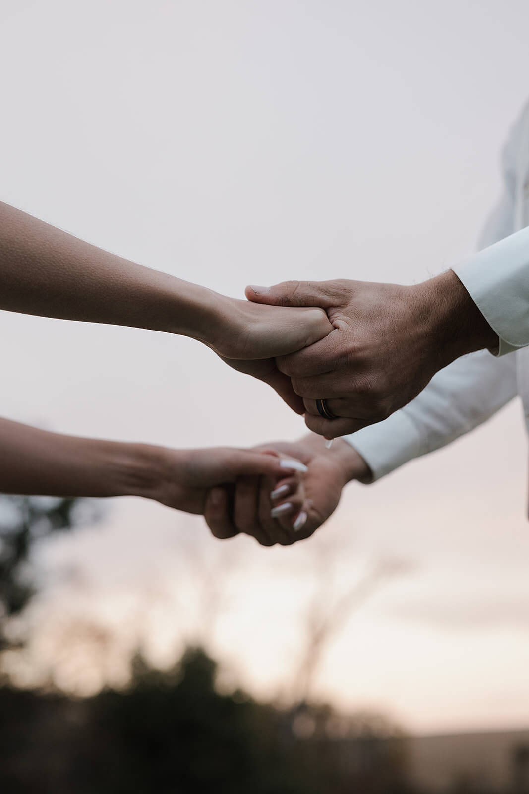 Close-up of a bride and groom holding hands at sunset during a Lancaster Wisconsin farm wedding