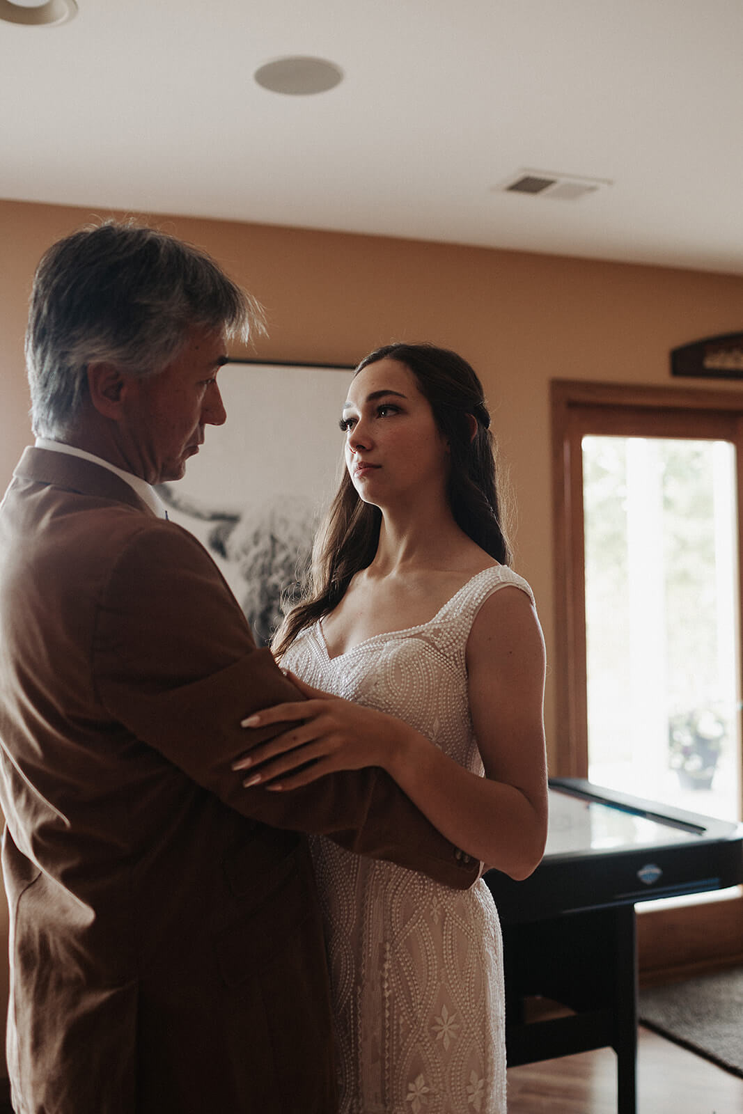 Father of the bride sharing a quiet moment with his daughter in her wedding gown inside the family farmhouse before the Lancaster Wisconsin wedding ceremony