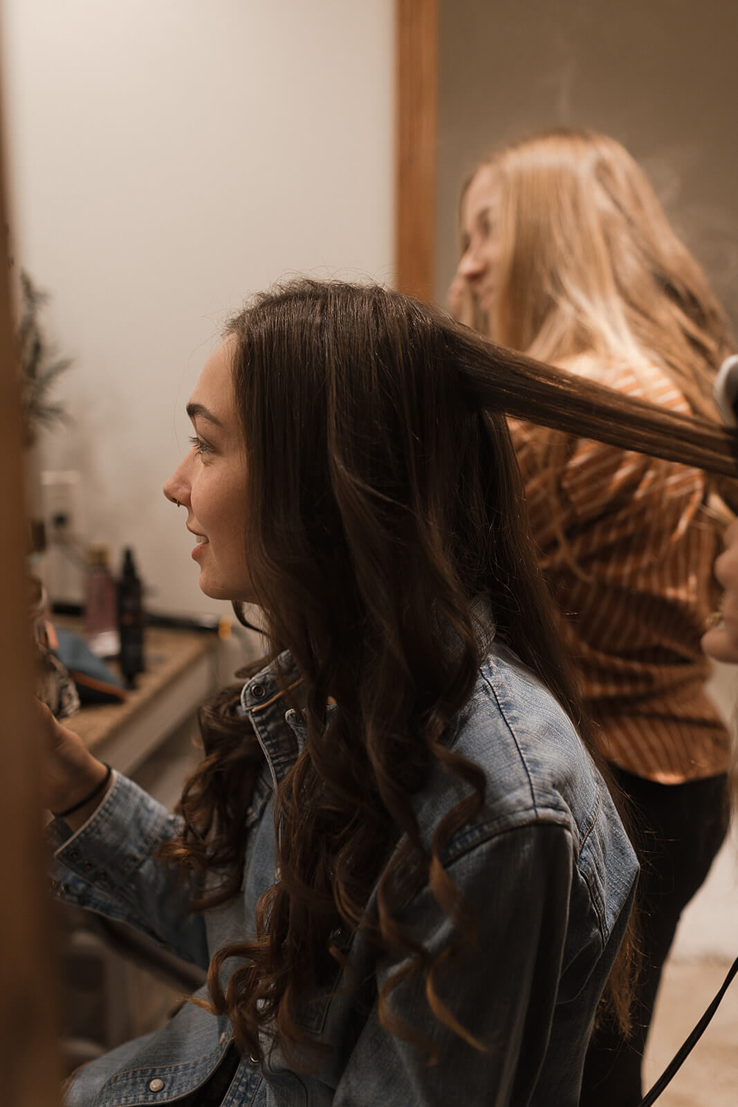 Bride getting her hair done on the morning of her Lancaster Wisconsin farmhouse wedding surrounded by family in the family home