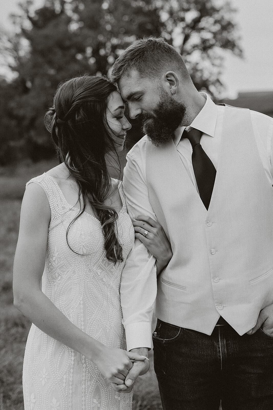 Black and white photo of a bride and groom leaning toward each other during Lancaster Wisconsin farm wedding portraits