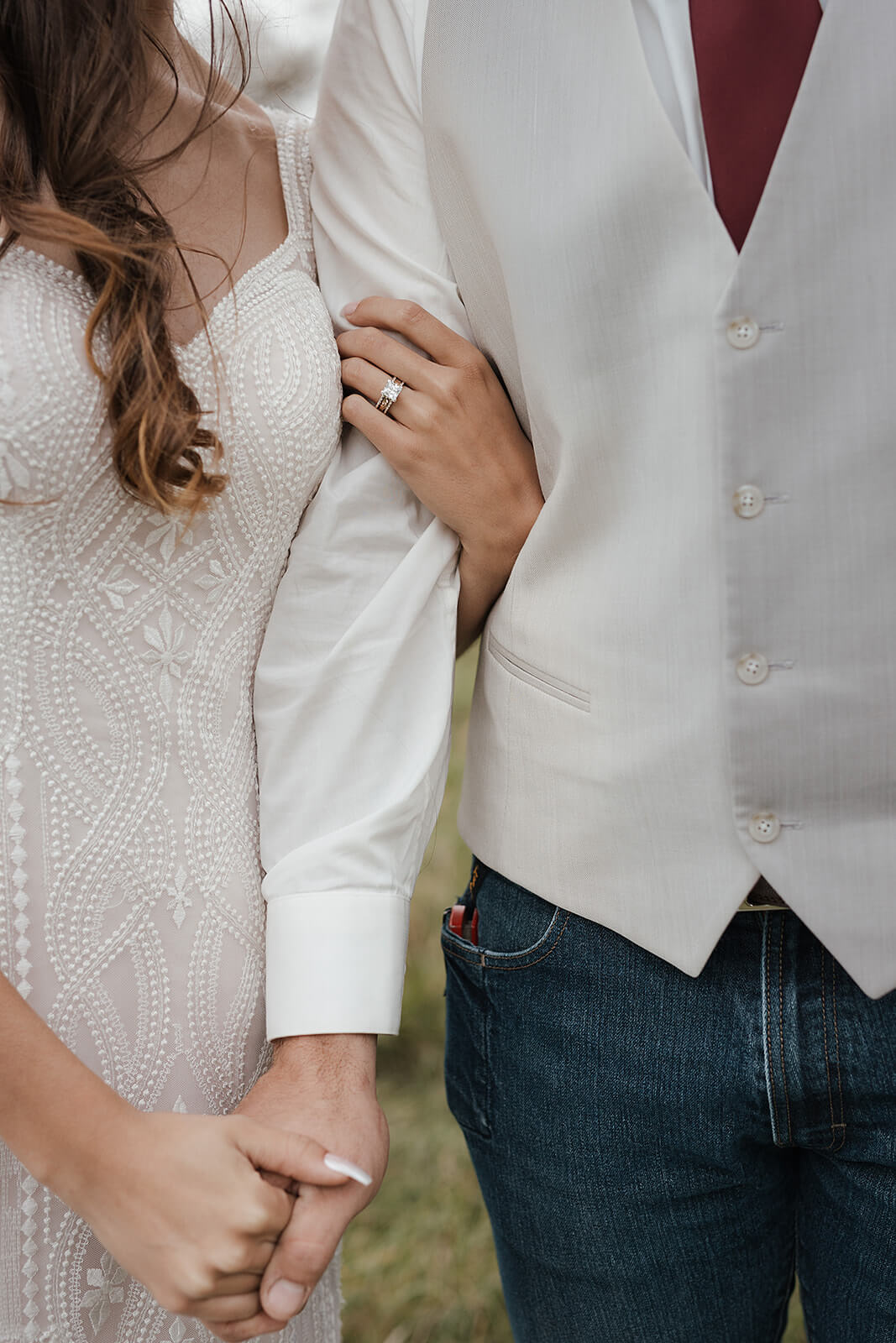 Close-up of a bride and groom holding hands showing her wedding ring during Lancaster Wisconsin farmhouse wedding portraits
